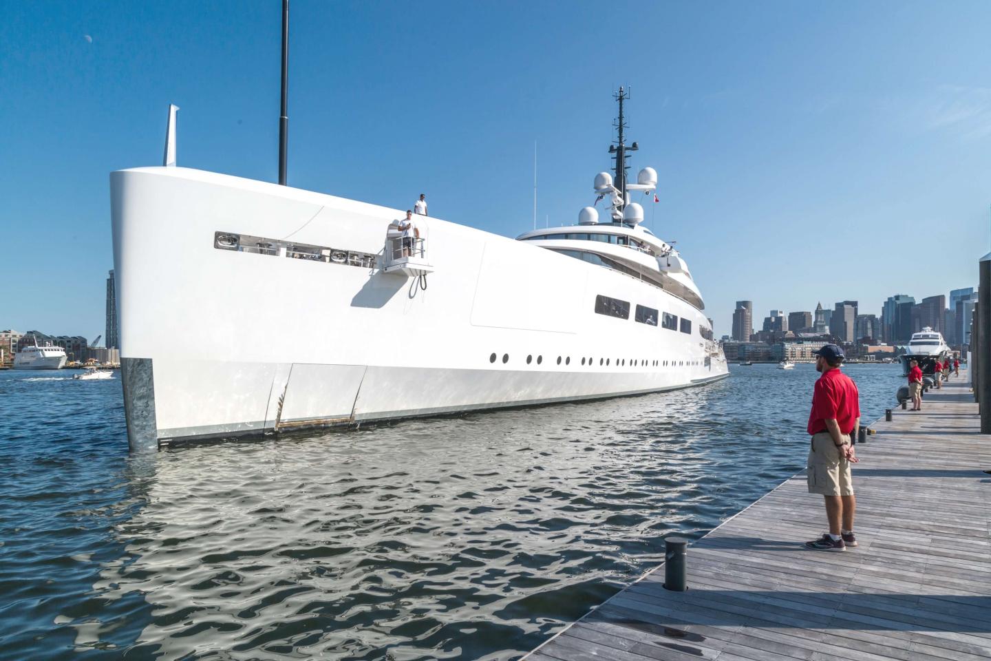 Staff watching a mega yacht approach the dock