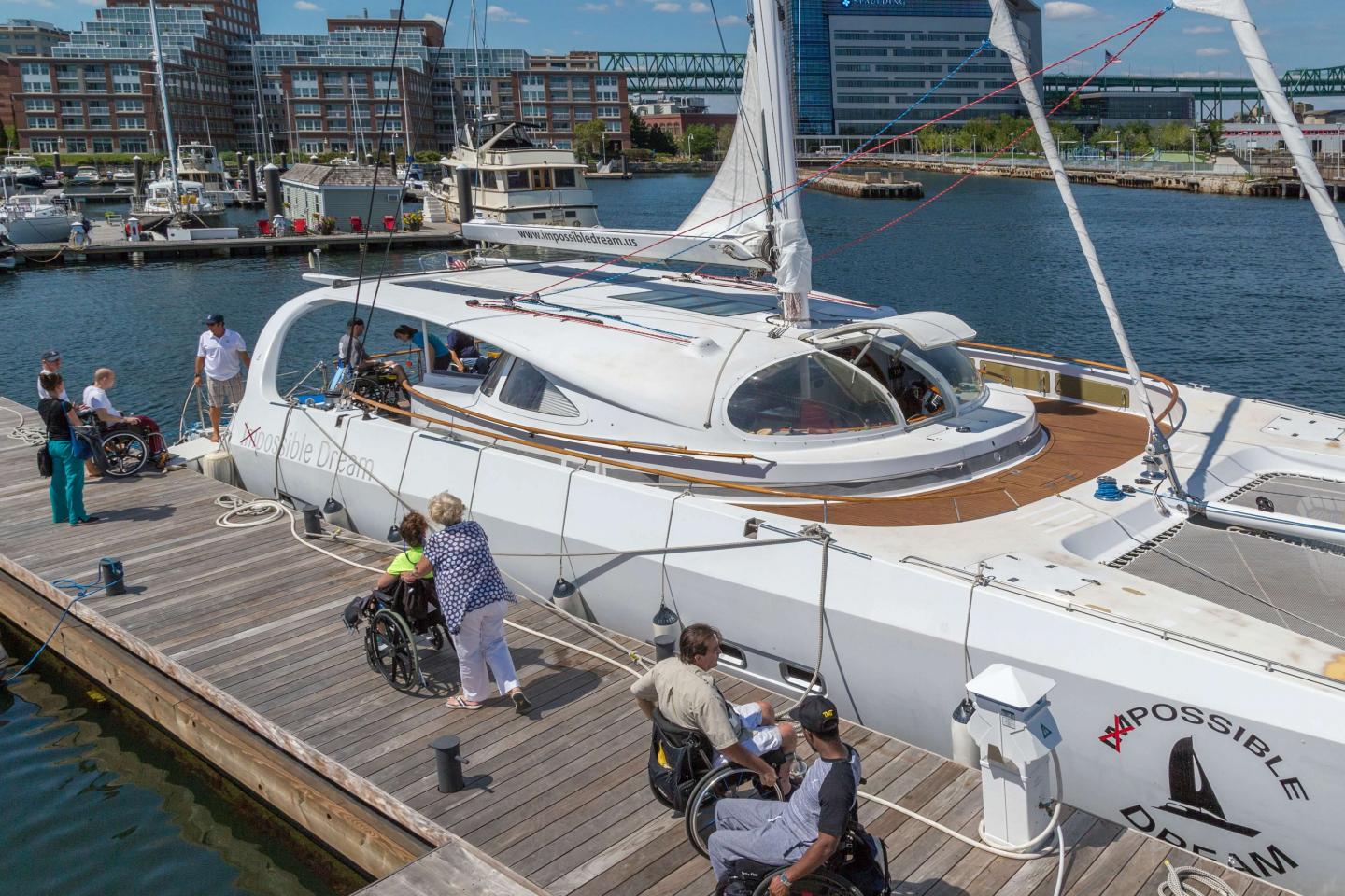 People in wheelchairs boarding a yacht