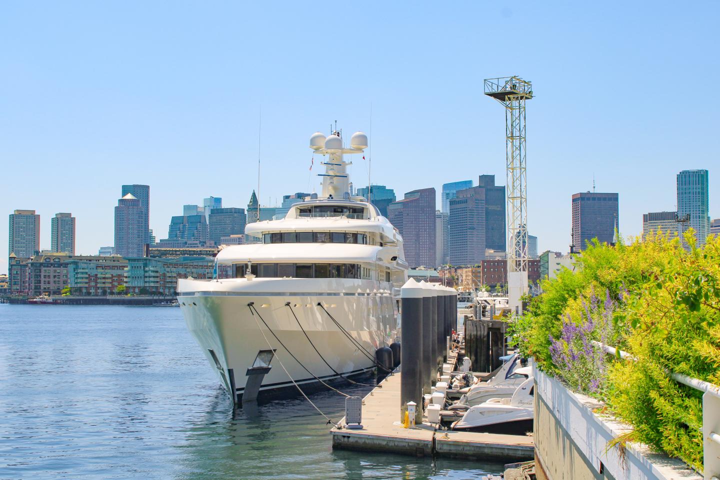 Yacht docked on the breakwater at Charlestown Marina with Boston skyline in the background.